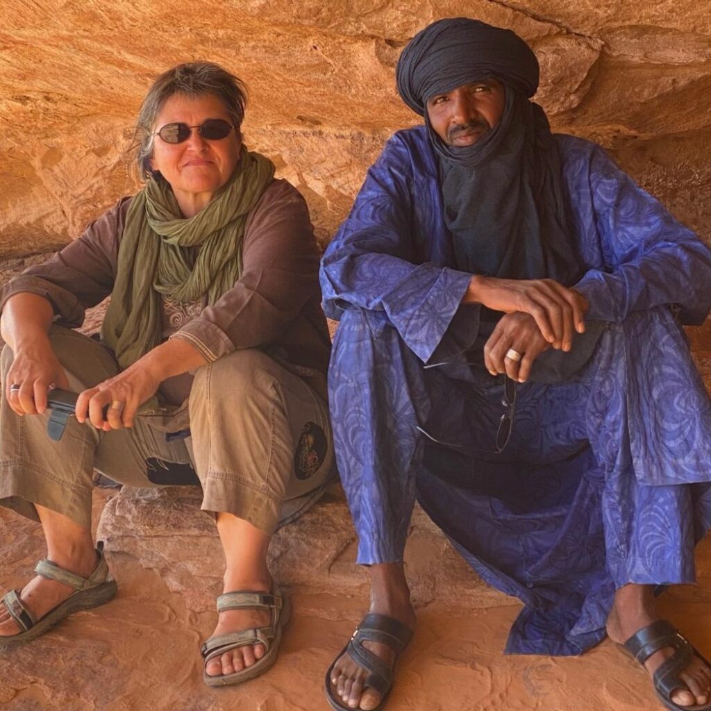 Franziska und Malek, die Verantwortlichen von VoyagesSudalgerien, sitzen im Schatten einer Felsformation in der Tadrart Rouge