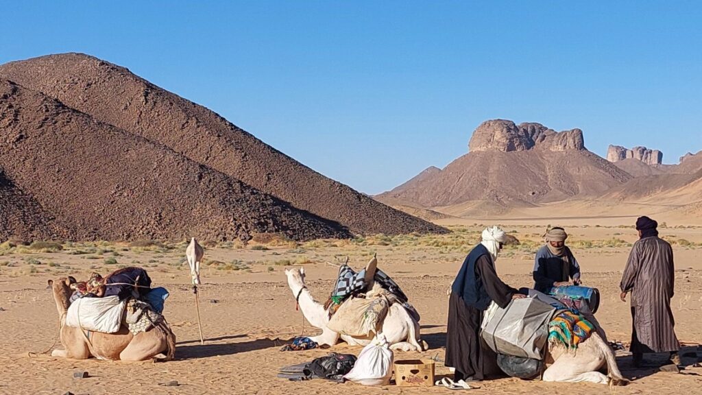 Beladen der Kamele in der Admer-Ebene zwischen Djanet und Essendilène, umgeben von Felsen und Sand