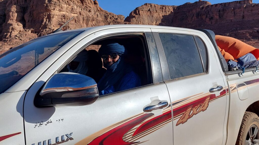 Tuareg‑Guide im Geländewagen auf einer Wüstenpiste nahe Djanet